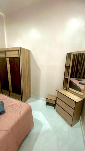 ein Schlafzimmer mit einem Bett und eine Kommode mit einem Spiegel in der Unterkunft Nazla Homestay Pendang 2 in Pendang