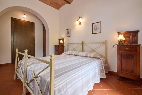 a bedroom with a bed and a wooden cabinet at Antichi Palmenti - Corbezzolo in San Vincenzo