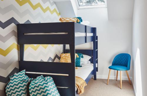 a bunk bed in a room with a blue chair at Beach House in Pennygown