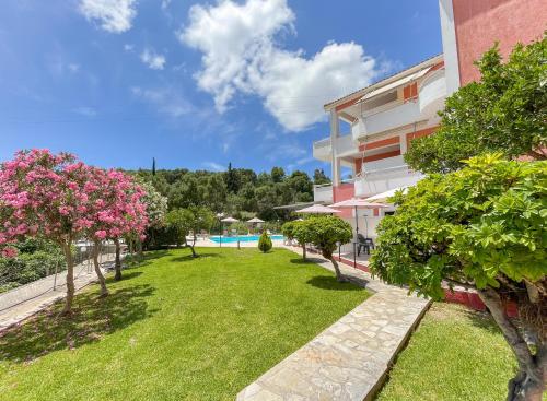 a courtyard of a building with a lawn and trees at Amazona Apartments and Studios in Spartià