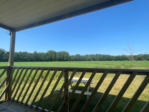a view of a field from the deck of a house at Ieberen lodge in Schoonloo