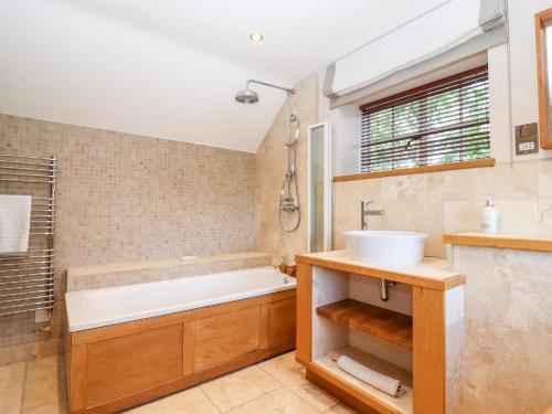 a bathroom with a tub and a sink at 1 The Lane in Chipping Norton