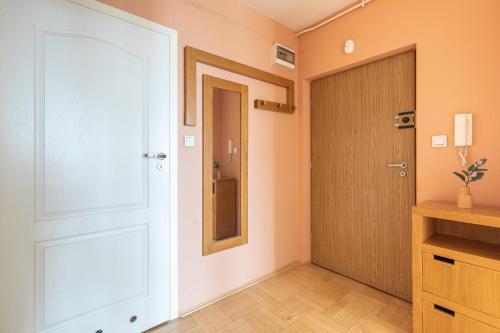 a hallway with a door and a mirror on the wall at SuperApart Dzieci Warszawy 27a in Warsaw