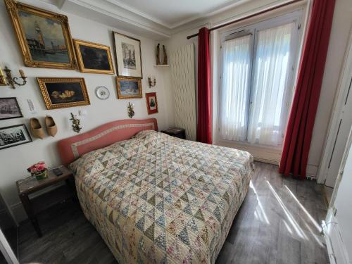 Schlafzimmer mit einem Bett, roten Vorhängen und einem Fenster in der Unterkunft Marie et Igor in Paris