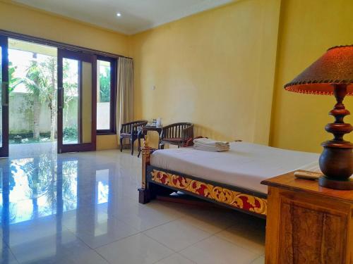 a bedroom with a bed and a table with a lamp at Hotel rooms 2 minutes to Monkey Forest in Ubud