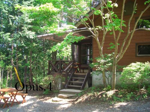 a wooden house with stairs leading to a porch at Shikitei in Fujiyoshida