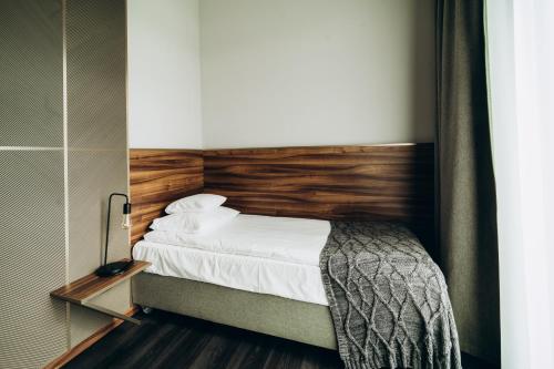 a bedroom with a bed with a wooden headboard at Lake Hill Karkonosze Resort & Spa in Sosnówka