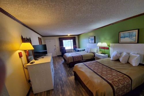 a hotel room with two beds and a desk at Days Inn by Wyndham Monett in Monett