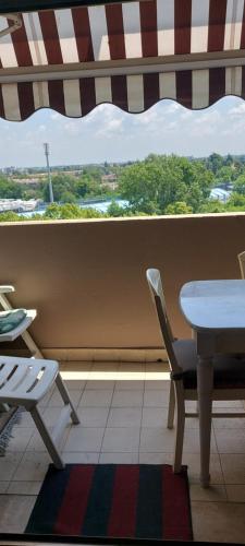 stół i krzesła w pokoju z oknem w obiekcie Stanza in appartamento privato Zona San vitale w Bolonii