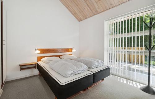 1 dormitorio con cama y ventana grande en Rubinsen Skovhuse, en Hasle