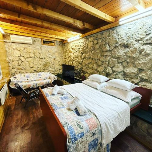 a bedroom with a bed and a stone wall at relax in Marusici 
