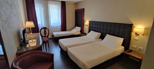 a hotel room with two beds and a desk at Best Western Park Hotel Continental in San Donà di Piave