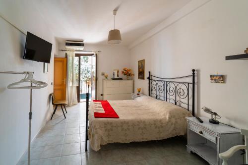 1 dormitorio con 1 cama con manta roja y TV en B&B gigi, en Benevento