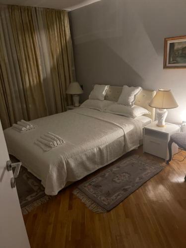 een slaapkamer met een bed en 2 lampen en een tapijt bij Vertu No1-Apartment in hearth of Sarajevo in Sarajevo