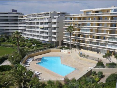 une piscine vide en face d'un grand bâtiment dans l'établissement Canet en Roussillon résidence en bord de mer, à Canet