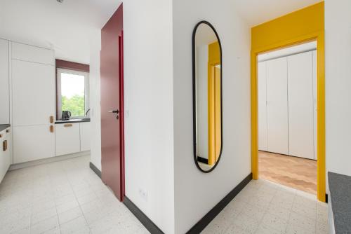 korytarz z białymi ścianami i lustrem w obiekcie Modernizmo by 3City Rentals w mieście Gdynia