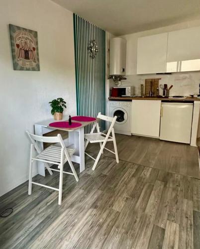 une cuisine avec une table et des chaises dans une pièce dans l'établissement Bright studio with balcony at the foot of the sea, à Nice