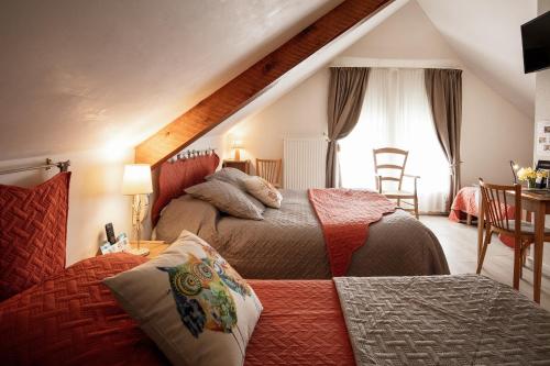 a bedroom with two beds and a window at Hôtel Restaurant de la Poste et La Grange Détente, espace bien-être in Châteauneuf-de-Randon