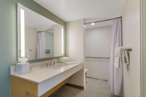 a bathroom with a sink and a mirror and a shower at Sonesta ES Suites Orlando International Drive in Orlando