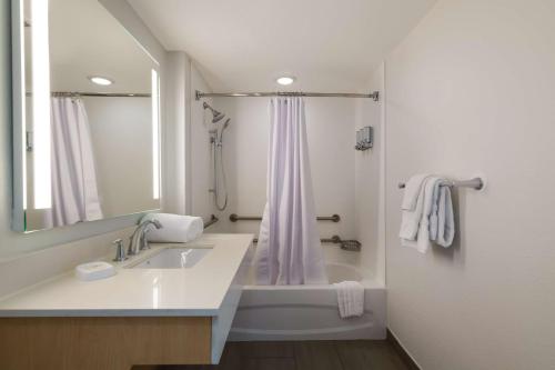 a white bathroom with a sink and a shower at Sonesta ES Suites Orlando International Drive in Orlando
