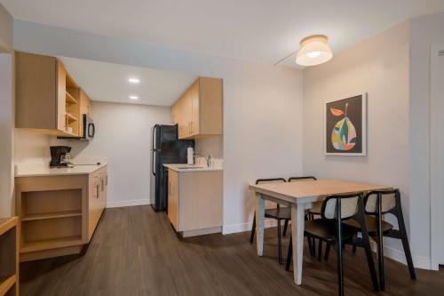 a kitchen and dining room with a table and a refrigerator at Sonesta ES Suites Orlando International Drive in Orlando