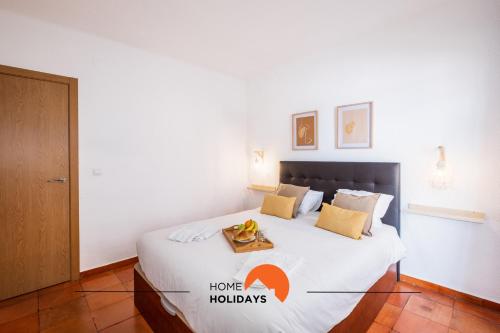 a bedroom with a large white bed with a table on it at #065 Zulmira Flat by Home Holidays in Vale de Pedras
