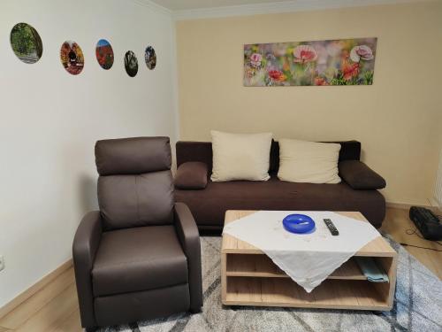 Rügen Fewo 303 في Gingst: غرفة معيشة مع أريكة وكرسي