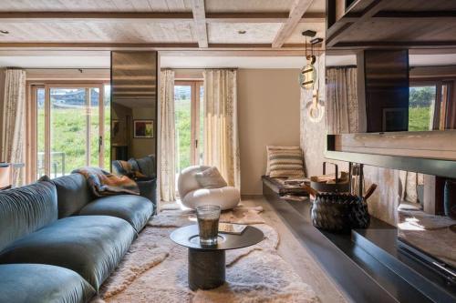 a living room with a couch and a fireplace at Rochebrune - Appartement de luxe in Megève