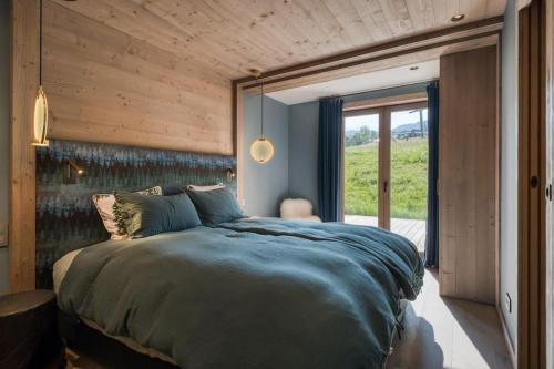 a bedroom with a large bed with a wooden wall at Rochebrune - Appartement de luxe in Megève