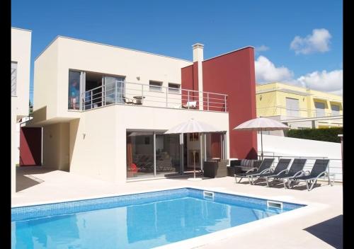 a villa with a swimming pool in front of a house at Foz Villa in Foz do Arelho