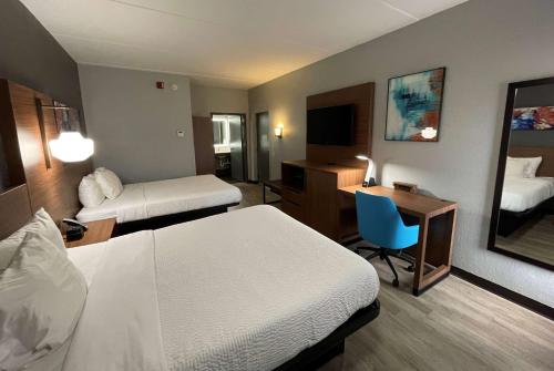 Cette chambre comprend deux lits et un bureau. dans l'établissement La Quinta Inn & Suites by Wyndham Fayetteville I-95, à Fayetteville