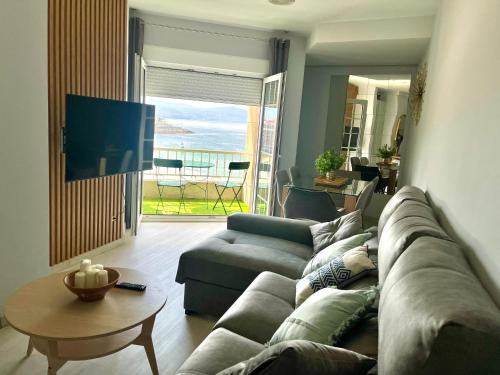a living room with a couch and a table at Martina & Playa in Sanxenxo
