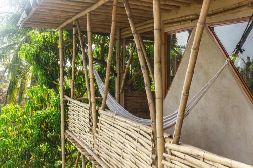 a hammock on the side of a tree house at Bambú Corner - Casa Consciente in Brisas de Zicatela