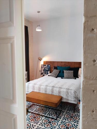 a bedroom with a bed and a bench on a rug at Walter's Guesthouse in Il-Gżira
