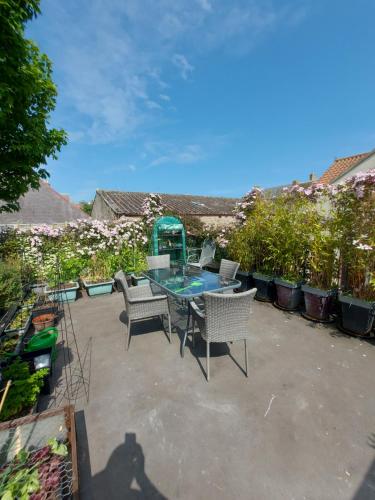 a patio with a table and chairs and flowers at Oil Mill Lane Holiday Cottage in Berwick-Upon-Tweed
