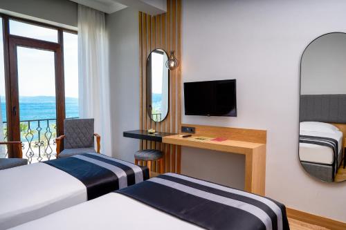 a hotel room with two beds and a television at Buyuk Truva Hotel in Canakkale