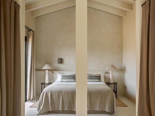 ein Schlafzimmer mit einem Bett mit zwei Lampen an zwei Tischen in der Unterkunft The Lodge Mallorca, Small Luxury Hotels in Sa Pobla