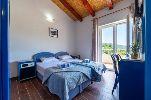 a bedroom with two beds and a large window at MAS Apartments in Kotor