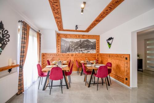 a dining room with tables and pink chairs at Cicha Woda 300 m od Gorący Potok i Termy Szaflary in Szaflary