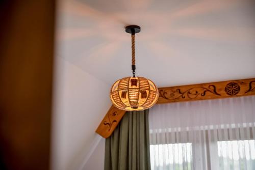 a wicker light hanging from a ceiling at Cicha Woda 300 m od Gorący Potok i Termy Szaflary in Szaflary