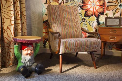 a toy elf sitting next to a chair at Hôtel Les Dames du Panthéon in Paris