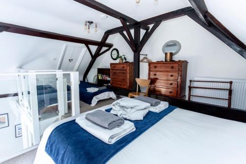a bedroom with a bed with towels on it at 4 The Old Schoolhouse: Parking, hot tub, garden, air con in Whitstable