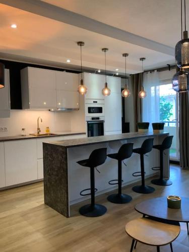 - une cuisine avec un bar avec des tabourets et une table dans l'établissement L’élégance du prado, à Marseille