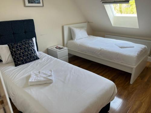 a small room with two beds and a window at RC Airport Rooms in Stanwell