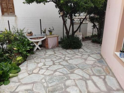 a stone patio with a table and a tree at Dream House in Agria