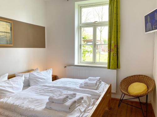 - une chambre avec un lit blanc et des serviettes dans l'établissement Ferienwohnung am Nationalpark, à Sassnitz