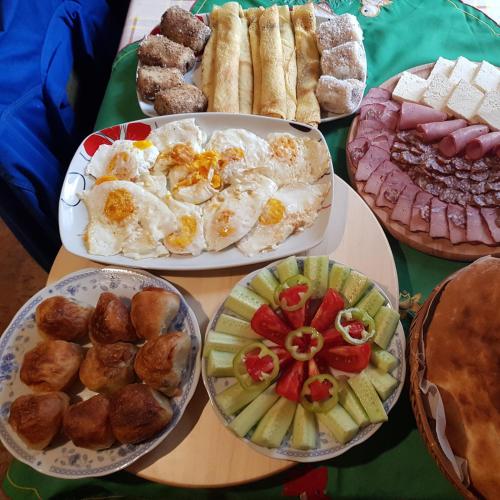 a table with plates of breakfast food on it at Konaciste Mali Izvor in Boljevac