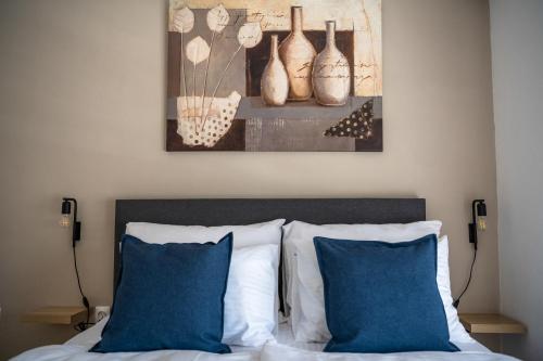 a bedroom with a bed with blue pillows and a painting at Apartment Fery in Mostar