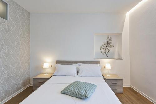 1 dormitorio con 1 cama blanca grande y 2 lámparas en Family Flat in the City Center by Wonderful Italy en Génova