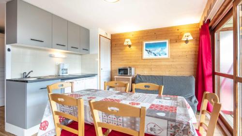 une cuisine et une salle à manger avec une table et des chaises dans l'établissement V du Bachat Asters B21 - Appt 6 pers, à Chamrousse